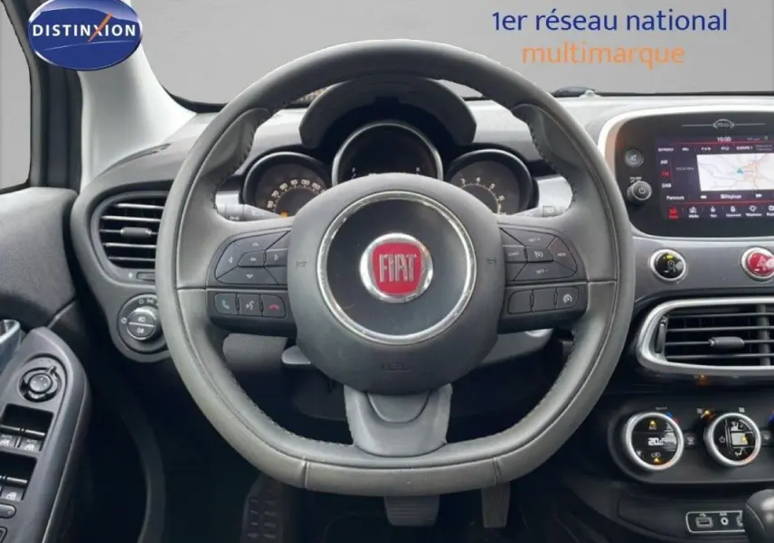 Vue intérieure centrée sur le volant FIAT d'une 500X MY18, avec tableau de bord et écran tactile visibles.