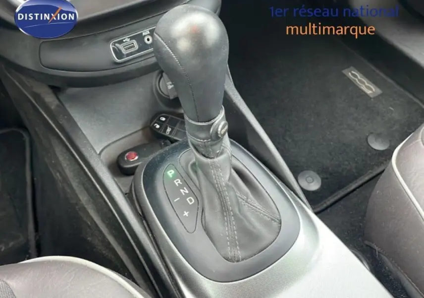 Le levier de vitesse automatique en cuir noir de la FIAT 500X MY18 gris foncé, vue intérieure centrée sur la console centrale.