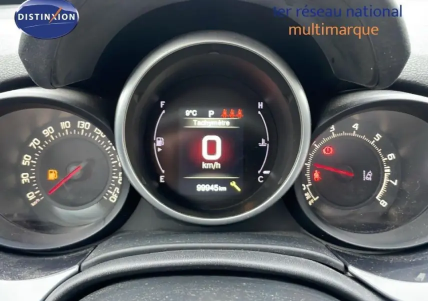 Tableau de bord de Fiat 500X gris foncé, affichage numérique à 0 km/h avec compte-tours et jauge carburant visibles.