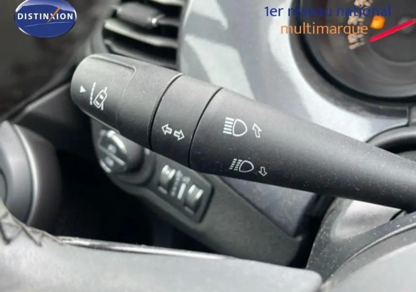 Gros plan sur la commande des phares et clignotants du Fiat 500X MY18 gris foncé, tableau de bord en arrière-plan.