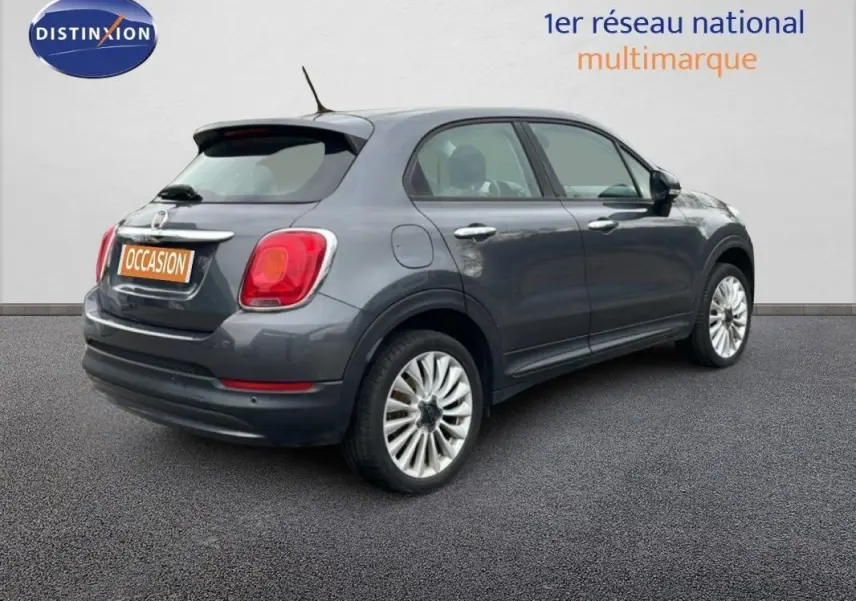 Fiat 500X gris foncé vue 3/4 arrière droit avec jantes alliage 18 pouces sur fond neutre.