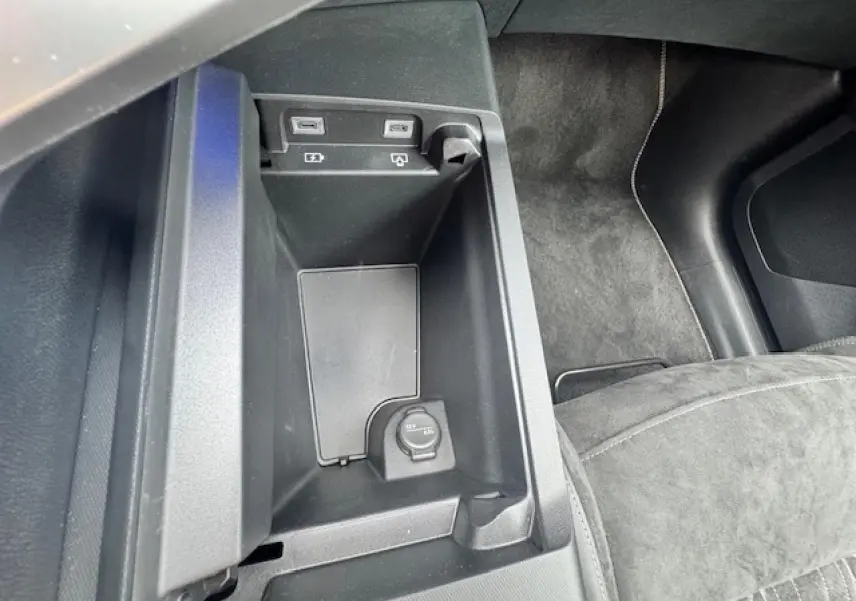 Vue rapprochée de la console centrale intérieure du Peugeot 3008 II gris, montrant prises USB et prise 12V.