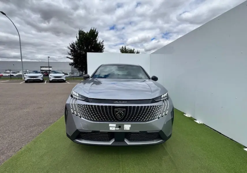 Vue avant d'un Peugeot 3008 gris Artense avec toit noir, calandre large et logo lion central bien visible.