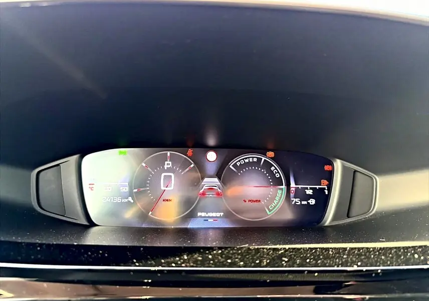 Vue rapprochée du tableau de bord numérique de la Peugeot 408 Hybrid 145 allure noir, affichant la vitesse et les indicateurs d'énergie.