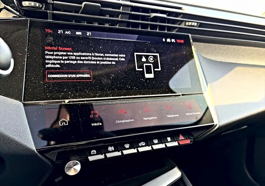 Vue rapprochée de la console centrale noire de la Peugeot 408 Hybrid 145 avec écran tactile et commandes tactiles.