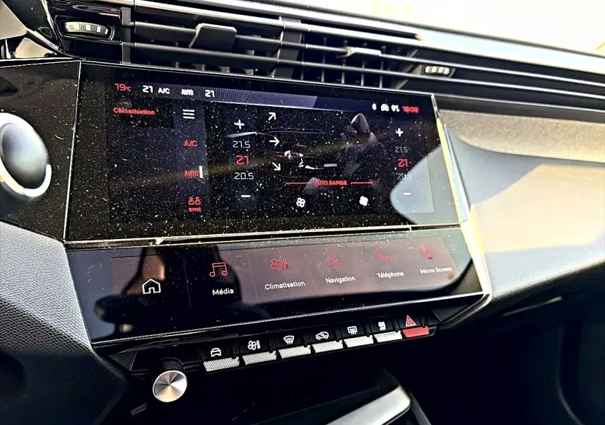 Vue rapprochée de la console centrale tactile de la Peugeot 408 Hybrid 145 allure, affichant la climatisation.