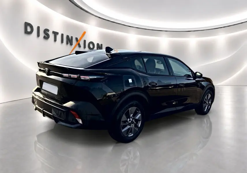 Peugeot 408 Hybrid 145 allure noir vue 3/4 arrière droit dans un showroom lumineux avec jantes alu.