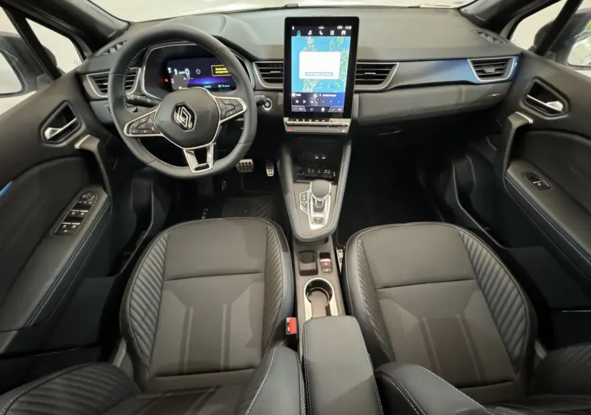 Intérieur noir du Renault Captur Esprit Alpine E-Tech 2025 vu de face, avec écran tactile vertical central et volant multifonctions.