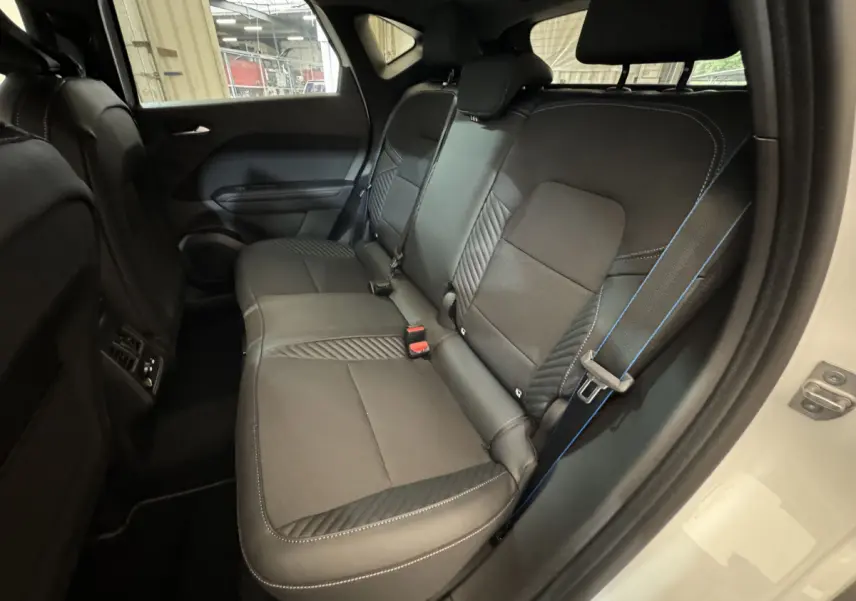 Banquette arrière noire avec surpiqûres bleues dans un Renault Captur blanc, vue côté droit arrière ouvert.