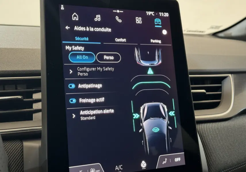 Écran tactile central du tableau de bord du Renault Captur blanc 2025 montrant les aides à la conduite.
