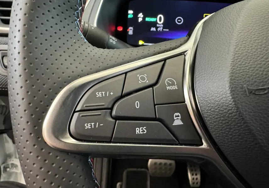 Gros plan sur les commandes gauche du volant cuir perforé du Renault Captur Esprit Alpine E-Tech blanc 2025.