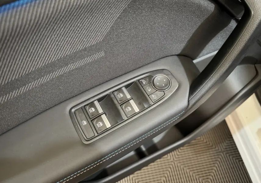 Gros plan sur la commande des vitres et rétroviseurs côté conducteur du Renault Captur blanc esprit Alpine E-Tech 2025.