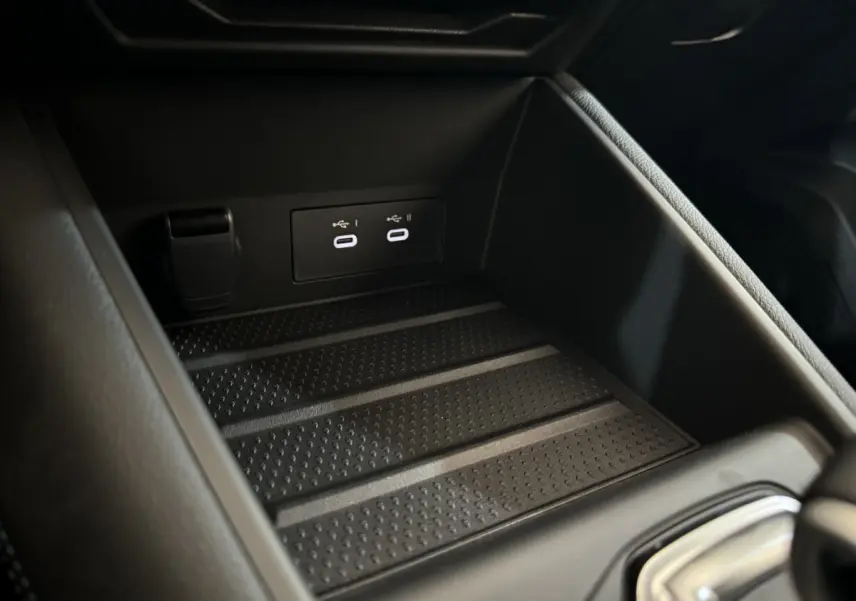 Gros plan sur la console centrale noire du Renault Captur esprit Alpine E-Tech avec deux ports USB-C éclairés.