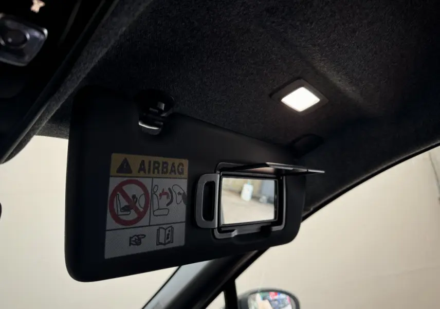 Détail du pare-soleil côté conducteur avec miroir intégré et éclairage intérieur allumé d'un Renault Captur blanc 2025.