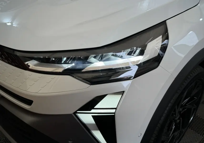 Gros plan sur le phare avant droit LED du Renault Captur blanc esprit Alpine E-Tech 2025 avec signature lumineuse distinctive.