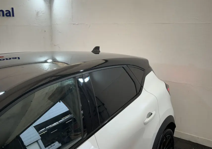 Vue 3/4 arrière droite du Renault Captur blanc avec toit noir et vitres teintées, version Esprit Alpine E-Tech.