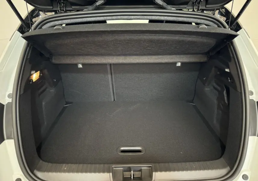 Coffre ouvert vu de l'arrière du Renault Captur blanc esprit Alpine E-Tech 2025, intérieur noir et éclairage latéral.