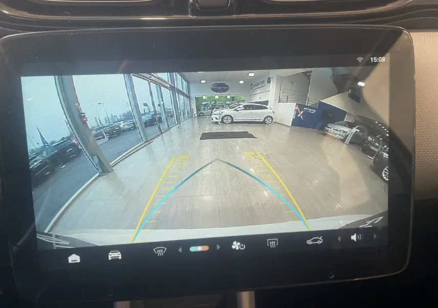 Vue caméra de recul sur l'écran tactile du tableau de bord, montrant l'arrière blanc du Leapmotor T03 Luxury en intérieur showroom.