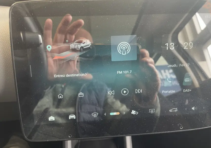 Écran tactile central du tableau de bord du Leapmotor T03 Luxury blanc, affichant navigation et radio FM.