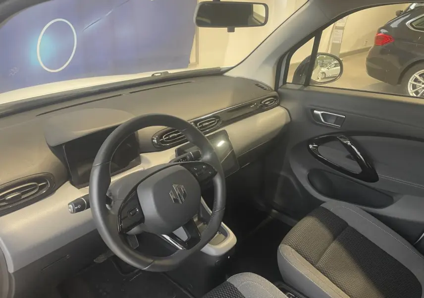 Vue intérieure côté conducteur du tableau de bord et volant cuir noir du LEAPMOTOR T03 Luxury blanc 2025.