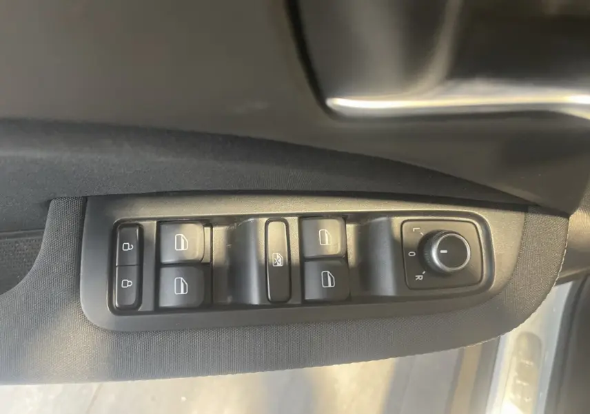 Vue rapprochée des commandes de vitres et rétroviseurs côté conducteur d'une LEAPMOTOR T03 Luxury blanche, 2025.