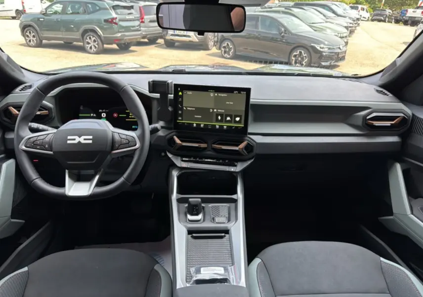 Vue intérieure avant du Dacia Bigster Hybrid 155 Extreme Plus avec tableau de bord digital et écran tactile central.