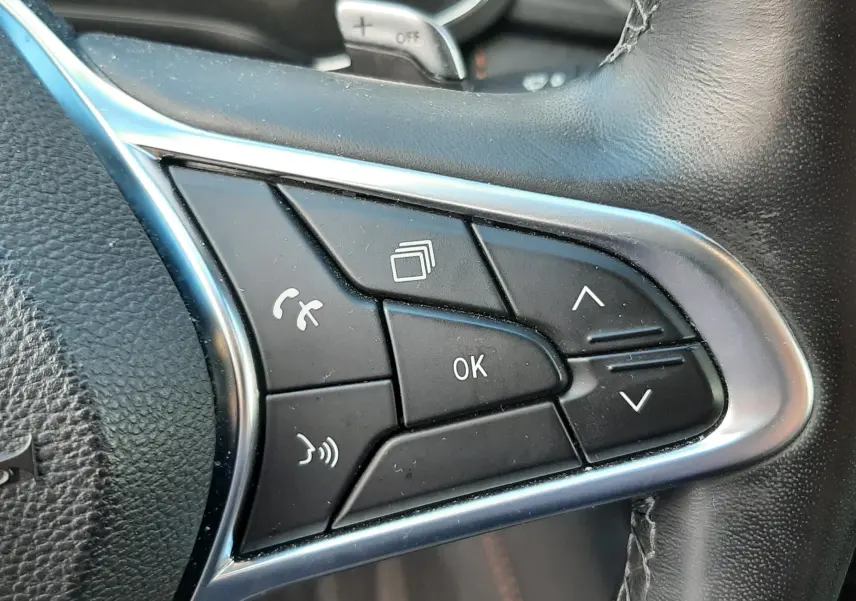 Gros plan sur les commandes multifonctions noires à droite du volant cuir du Renault Captur blanc toit noir 2020.