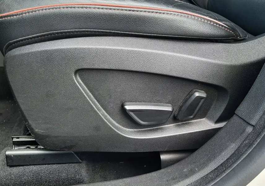 Vue rapprochée du côté gauche du siège avant en cuir noir avec surpiqûres rouges du Renault Captur blanc toit noir 2020.