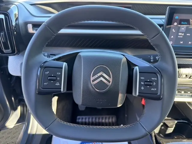 Vue rapprochée du volant cuir multifonctions de la Citroën C3 Turbo 100 BVM6 MAX 2025, intérieur gris foncé.