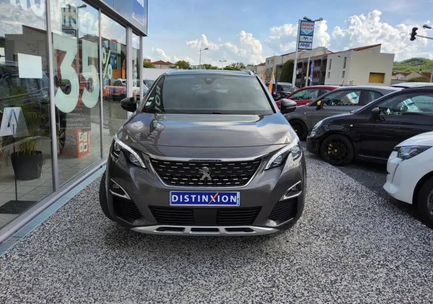 Peugeot 3008 gris métallisé vue de face, avec calandre chromée et plaques Distinxion visible.