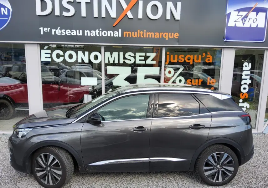 Peugeot 3008 GT Line gris métallisé vue de profil côté gauche devant une vitrine avec enseigne Distinxion.