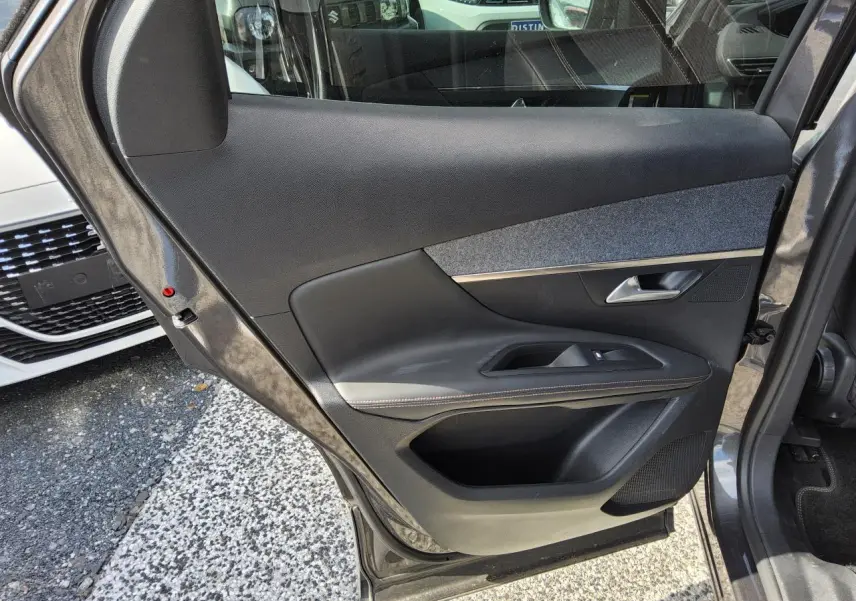 Gros plan sur la porte arrière gauche gris métallisé du Peugeot 3008 2017 avec garniture noire et insert tissu gris.
