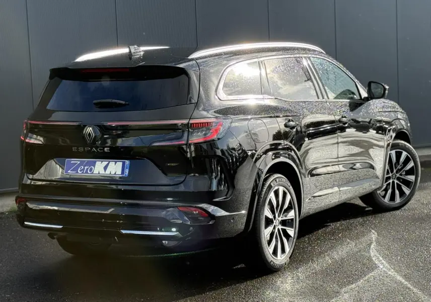 Renault Espace VI noir étoilé vu en 3/4 arrière droit, avec toit panoramique et jantes alliage 19 pouces.