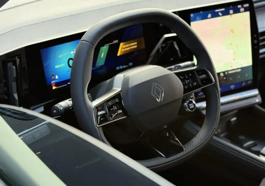 Volant noir au design moderne avec logo Renault, tableau de bord numérique et écran tactile central du Renault Espace 2025.