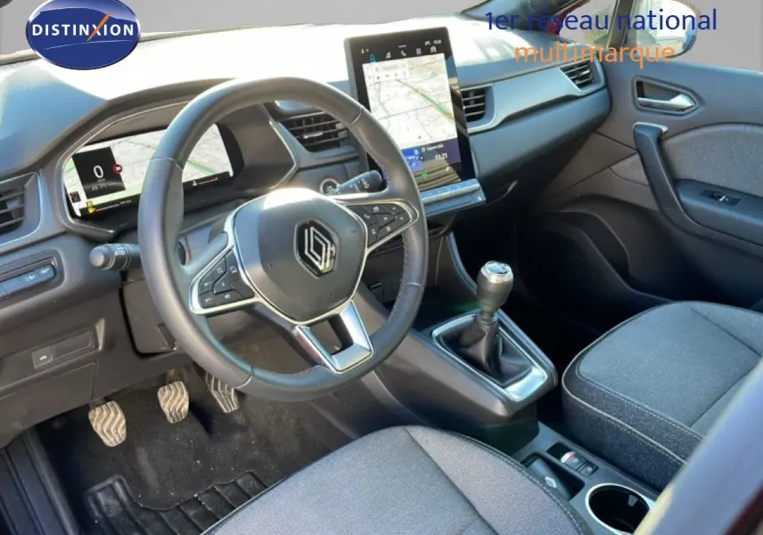 Vue intérieure côté conducteur du Renault Captur 2025, tableau de bord gris noir avec écran tactile vertical et volant cuir.