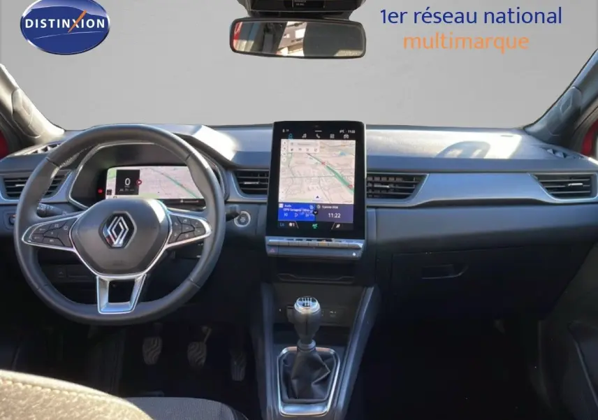 Vue intérieure avant du Renault Captur 2025 avec tableau de bord noir et écran tactile central vertical.