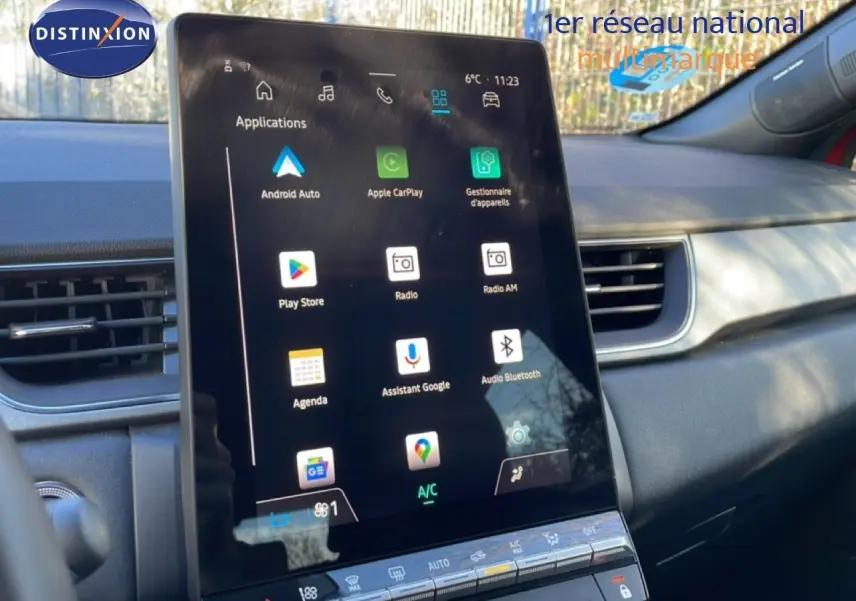 Vue intérieure centrée sur l'écran tactile vertical du tableau de bord du Renault Captur rouge Désir métal avec toit noir.