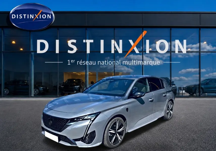 PEUGEOT 308 1.2 hybrid gris vue 3/4 avant droit, avec jantes alliage et calandre noire distinctive.