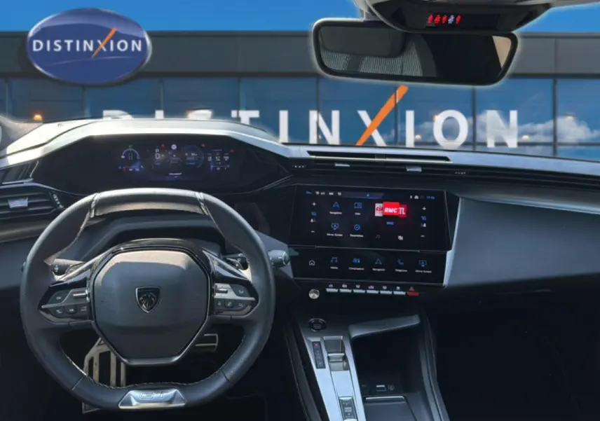 Vue intérieure avant du tableau de bord et volant noir de la Peugeot 308 1.2 hybrid 145 GT e-DCS6 2025, avec écran tactile et affichage numérique.