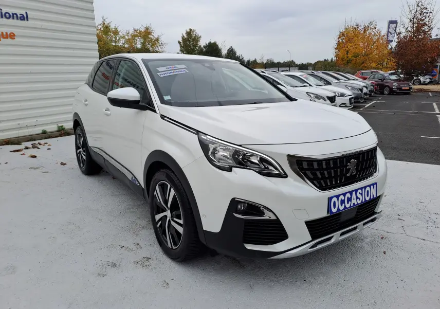 Peugeot 3008 blanc vue 3/4 avant droit avec calandre noire et jantes alliage bicolores sur parking.