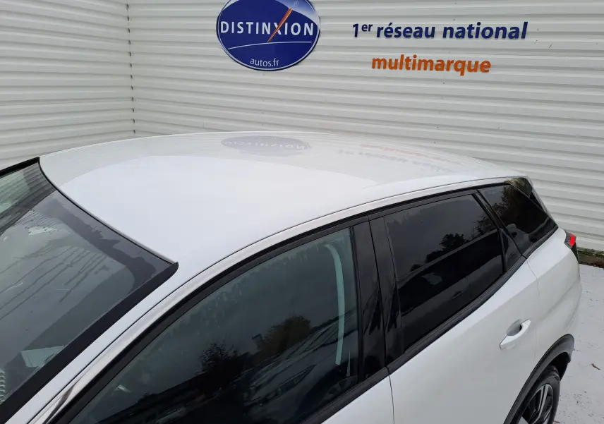 Vue de dessus et côté gauche d'un Peugeot 3008 blanc 2018 avec vitres teintées et jantes alliage.