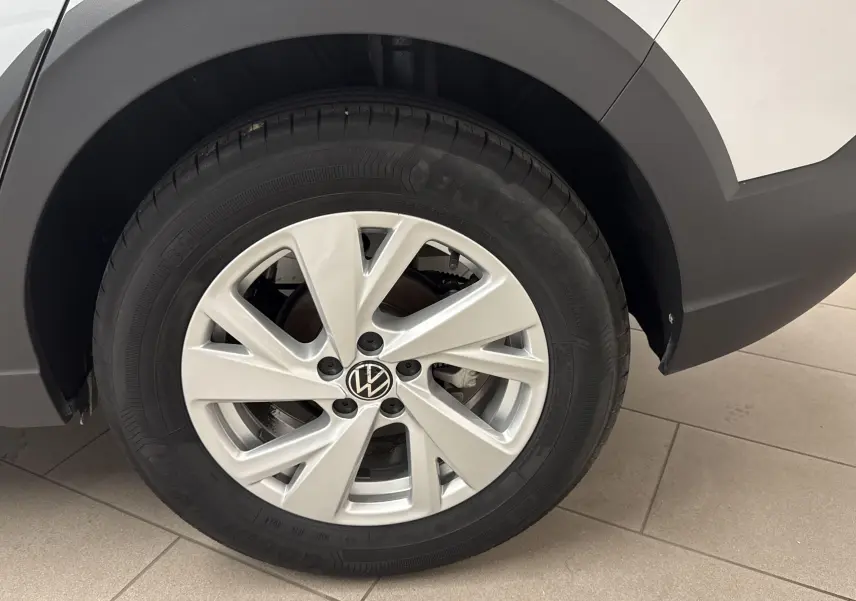 Gros plan sur la roue arrière droite du Volkswagen Taigo gris cendré, mettant en valeur la jante alliage et le logo VW central.