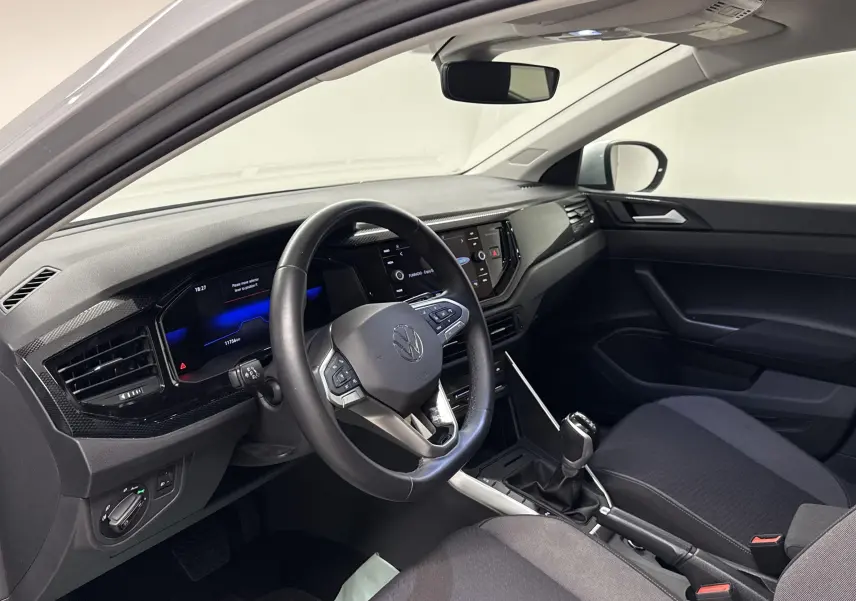 Intérieur avant droit du Volkswagen Taigo gris cendré 2024, tableau de bord moderne avec écran tactile et volant multifonction.