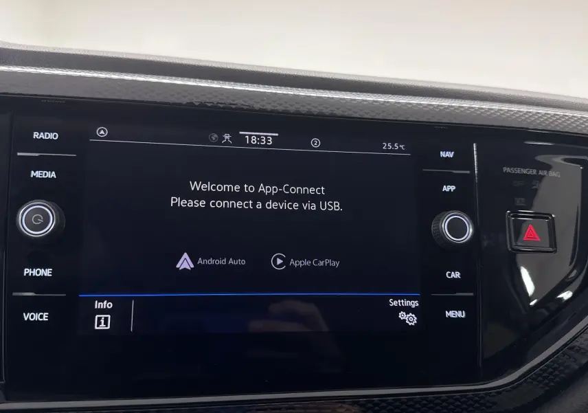 Écran tactile central du Volkswagen Taigo 2024 affichant l'interface App-Connect avec commandes autour en finition noire brillante.