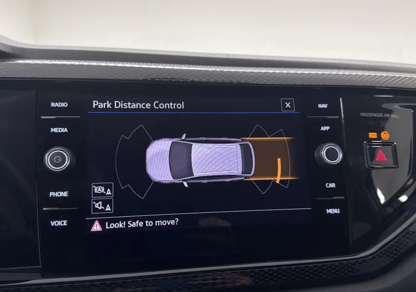 Écran central du Volkswagen Taigo 2024 montrant l'alerte de contrôle de distance au stationnement en vue de dessus.