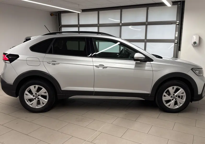 Profil droit d'un Volkswagen Taigo 1.0 TSI 110 DSG7 Life gris cendré métallisé en intérieur lumineux.