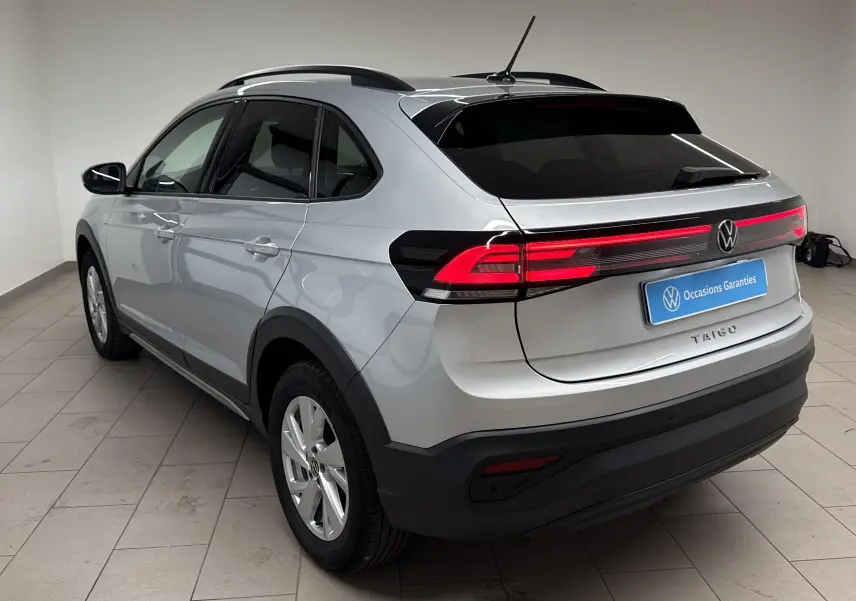 Vue 3/4 arrière droite du Volkswagen Taigo gris cendré 2024 avec feux arrière LED et toit noir contrasté.