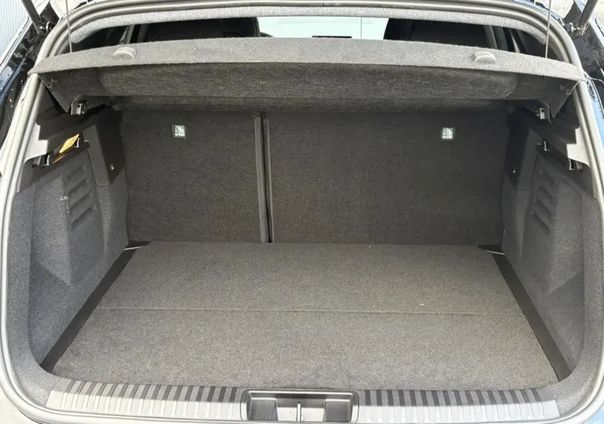 Coffre ouvert d'un Renault SYMBIOZ noir étoile, vue intérieure montrant l'espace de chargement vide et la moquette grise.