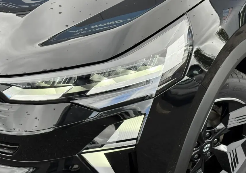 Gros plan sur le phare avant gauche et la jante 18" Gravity du Renault Symbioz noir étoile 2025.