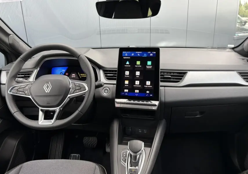 Intérieur Renault SYMBIOZ noir étoile, vue avant centrée sur tableau de bord avec écran tactile vertical et volant multifonction.
